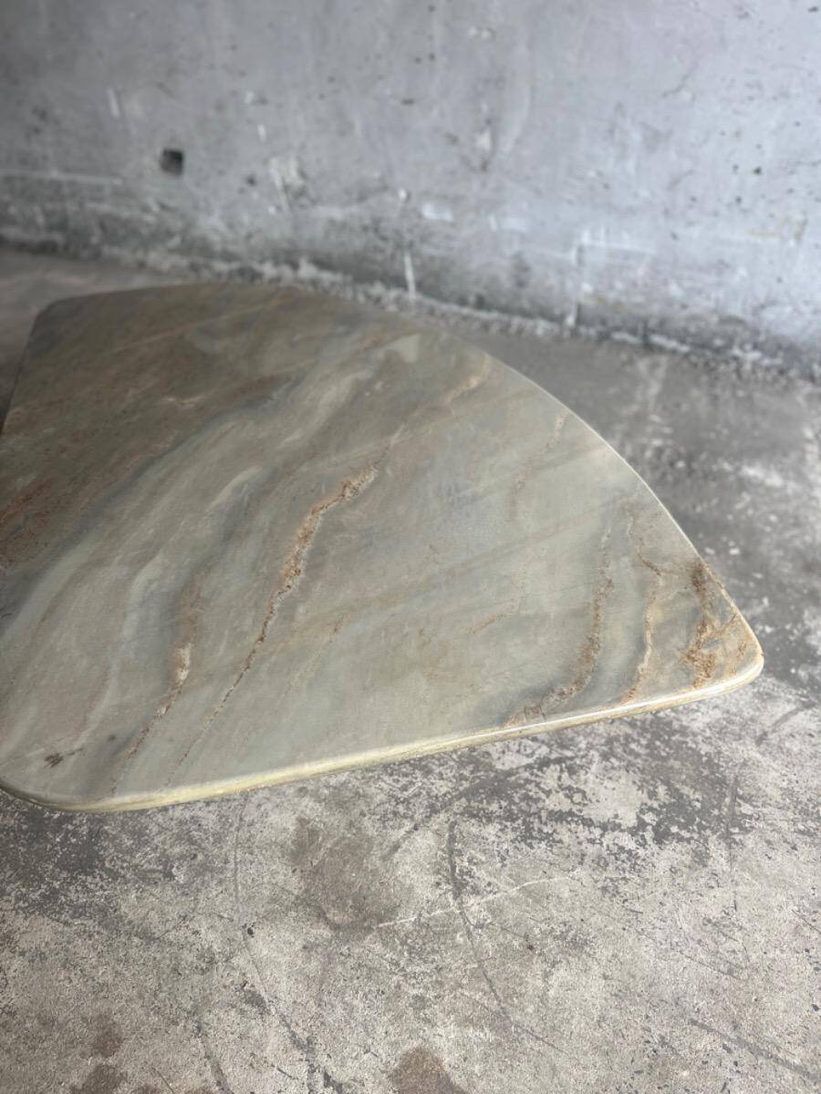 Light gray solid granite coffee table with organic triangular shape and conical base, 1980s
