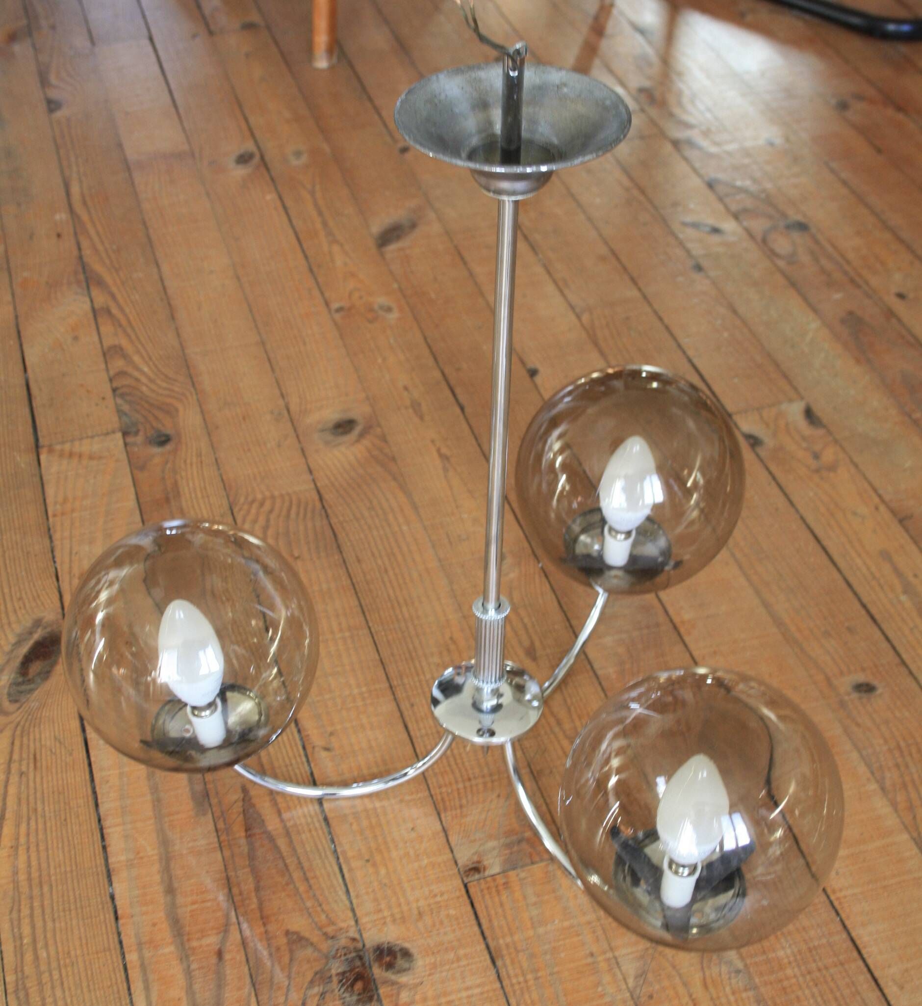 Chrome metal chandelier with smoked glass globes.