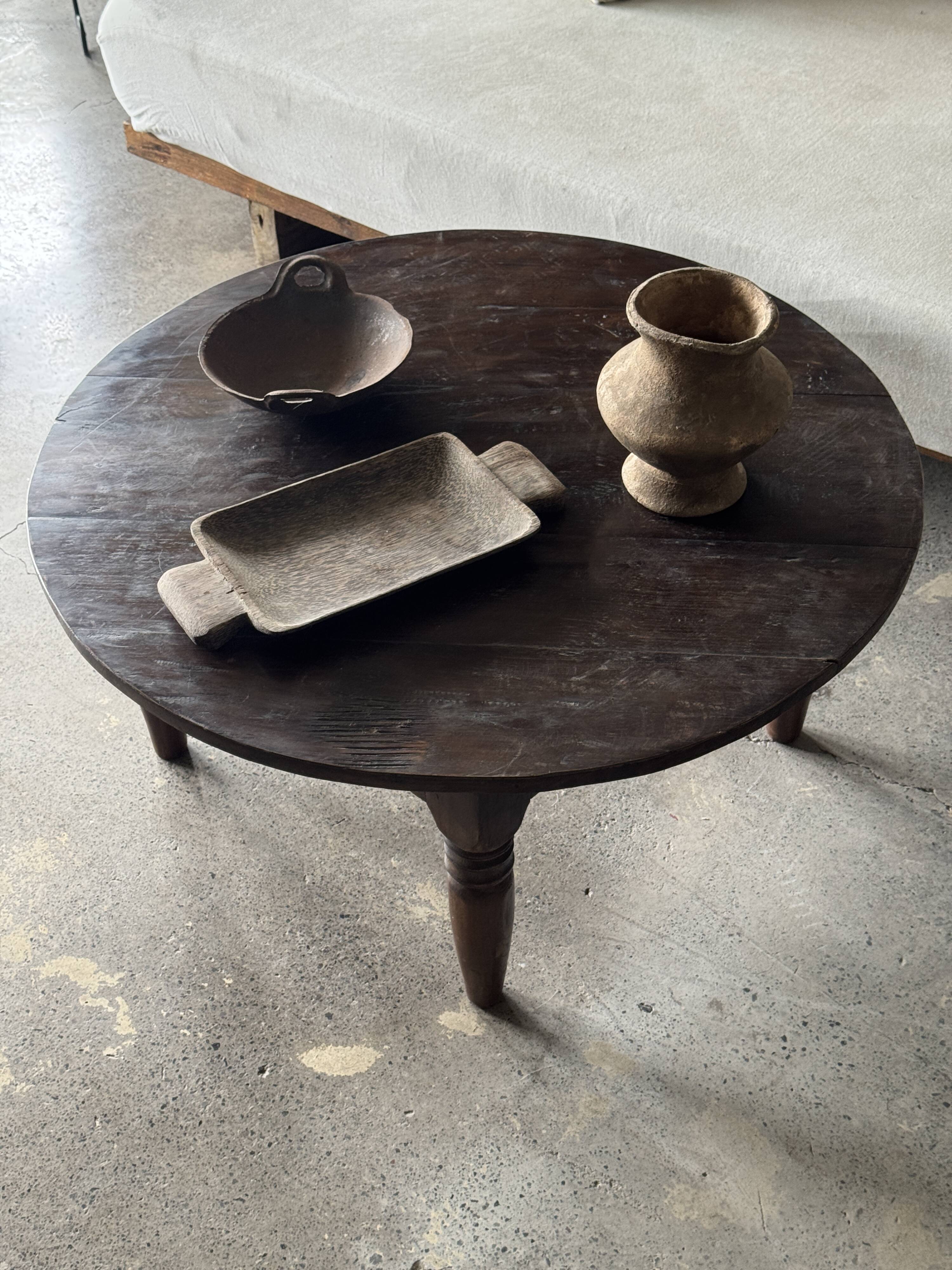 Coffee table, round antique Indonesian teak table with straight legs.