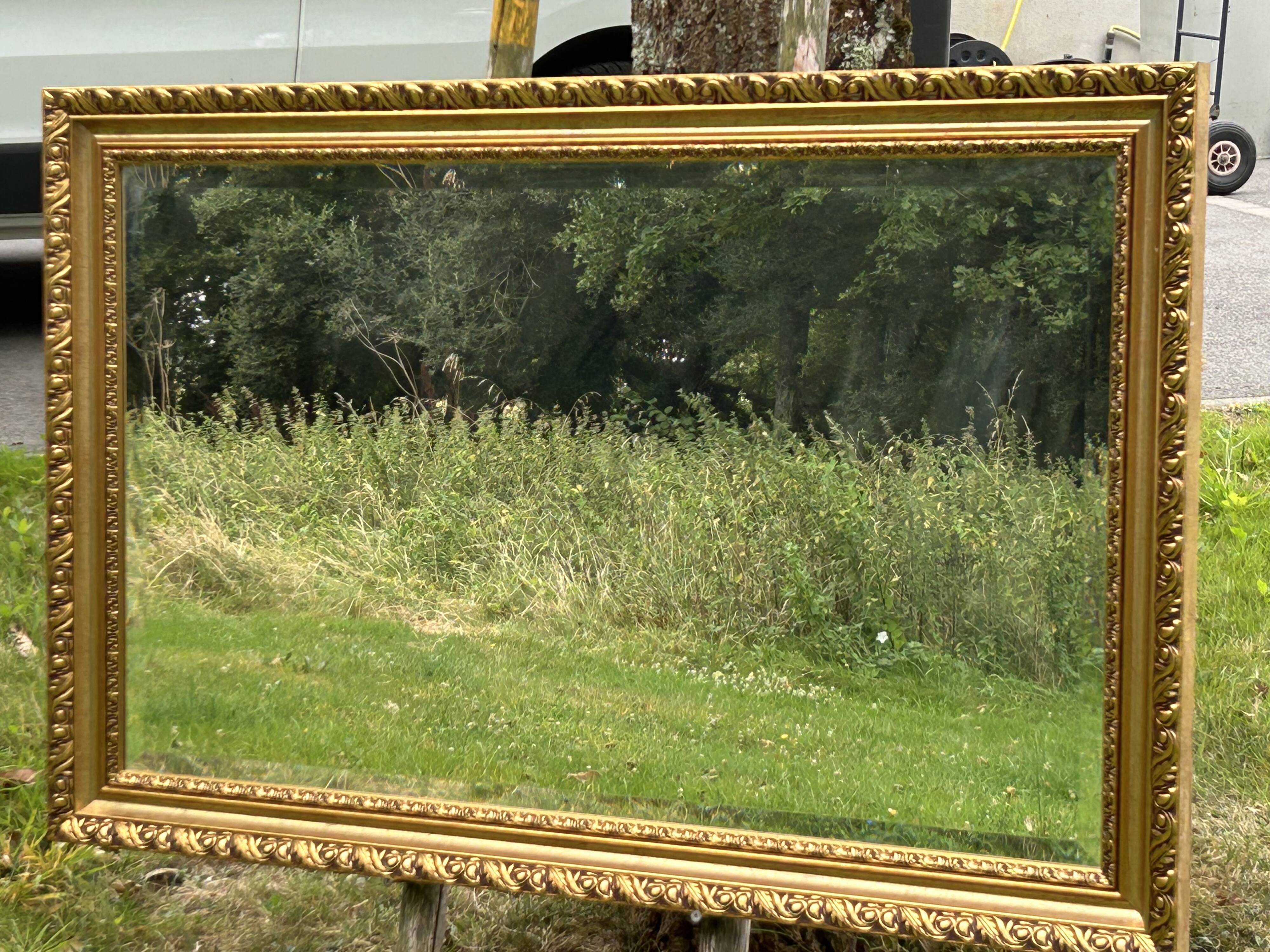 Large beveled mirror in wood and gilded stucco