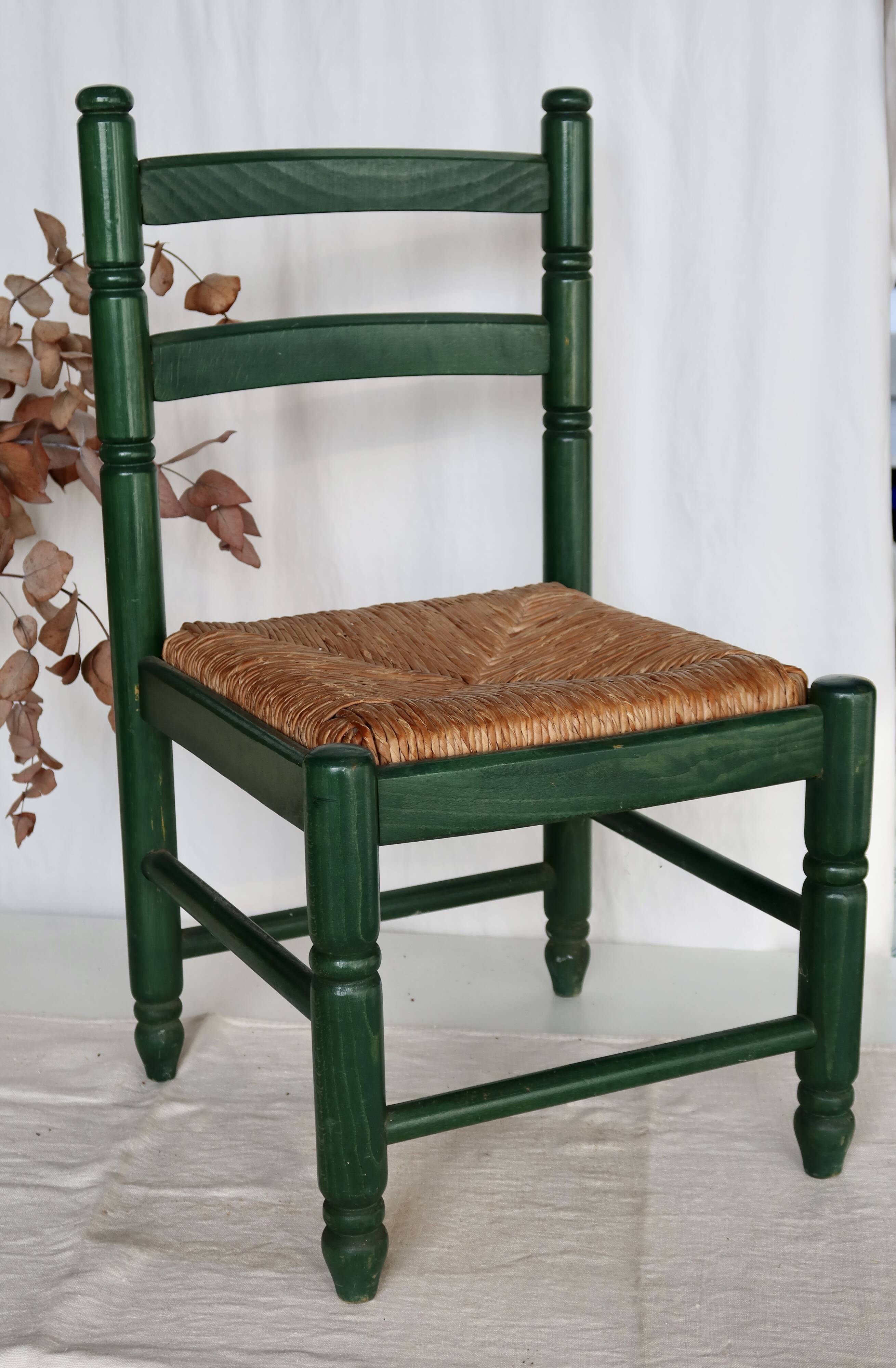 Vintage children's chair in green wood with a woven straw seat