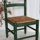 Vintage children's chair in green wood with a woven straw seat