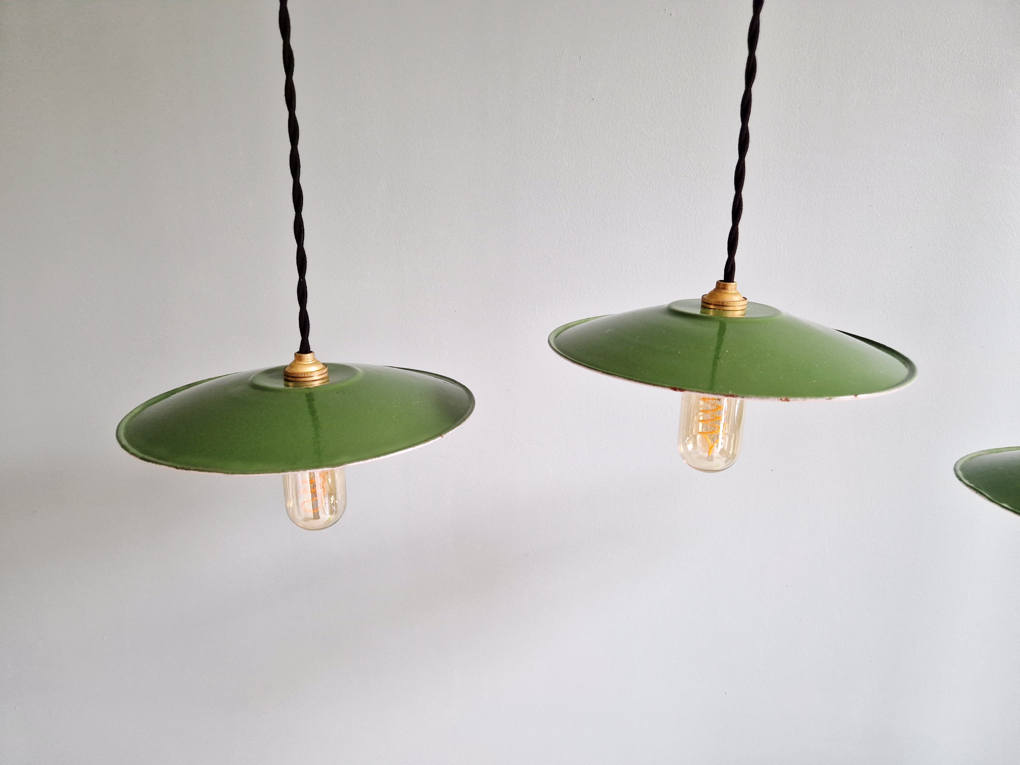Trio of large industrial suspensions in green enamelled sheet metal.
