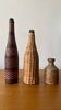 Assortment of bottles in rattan, leather, and stoneware.