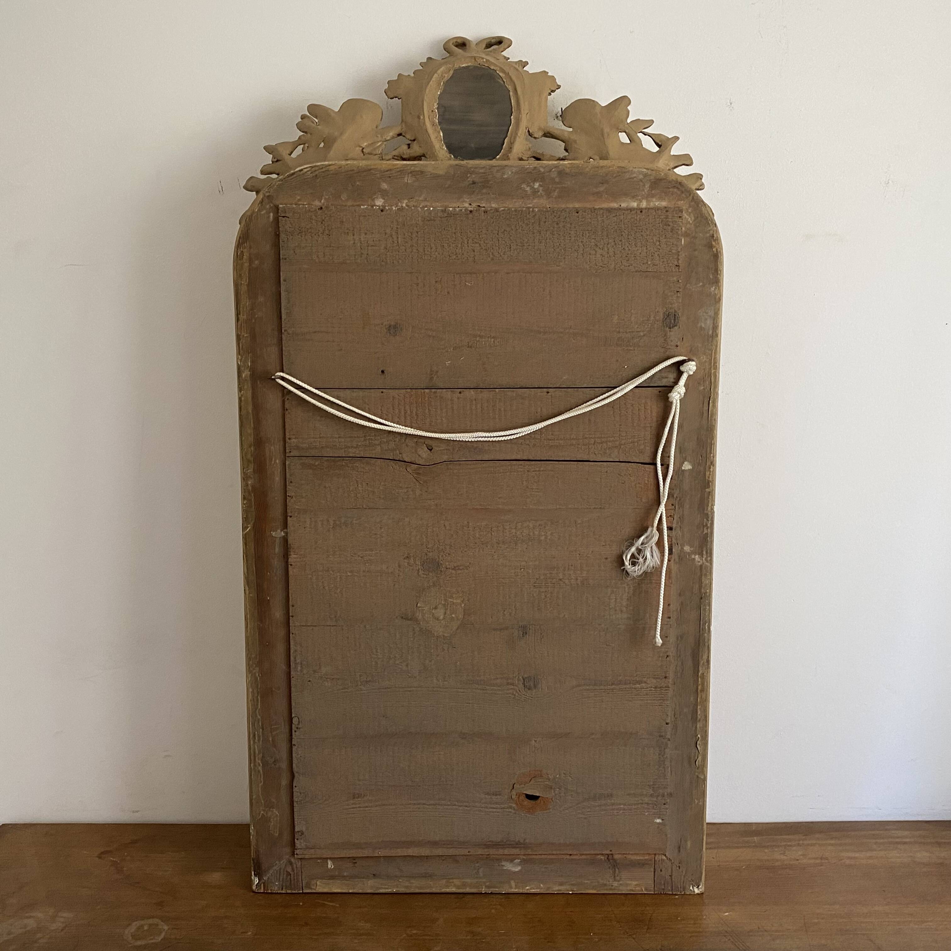 Late 19th century gilded mirror with decorated pediment. 125x70.
