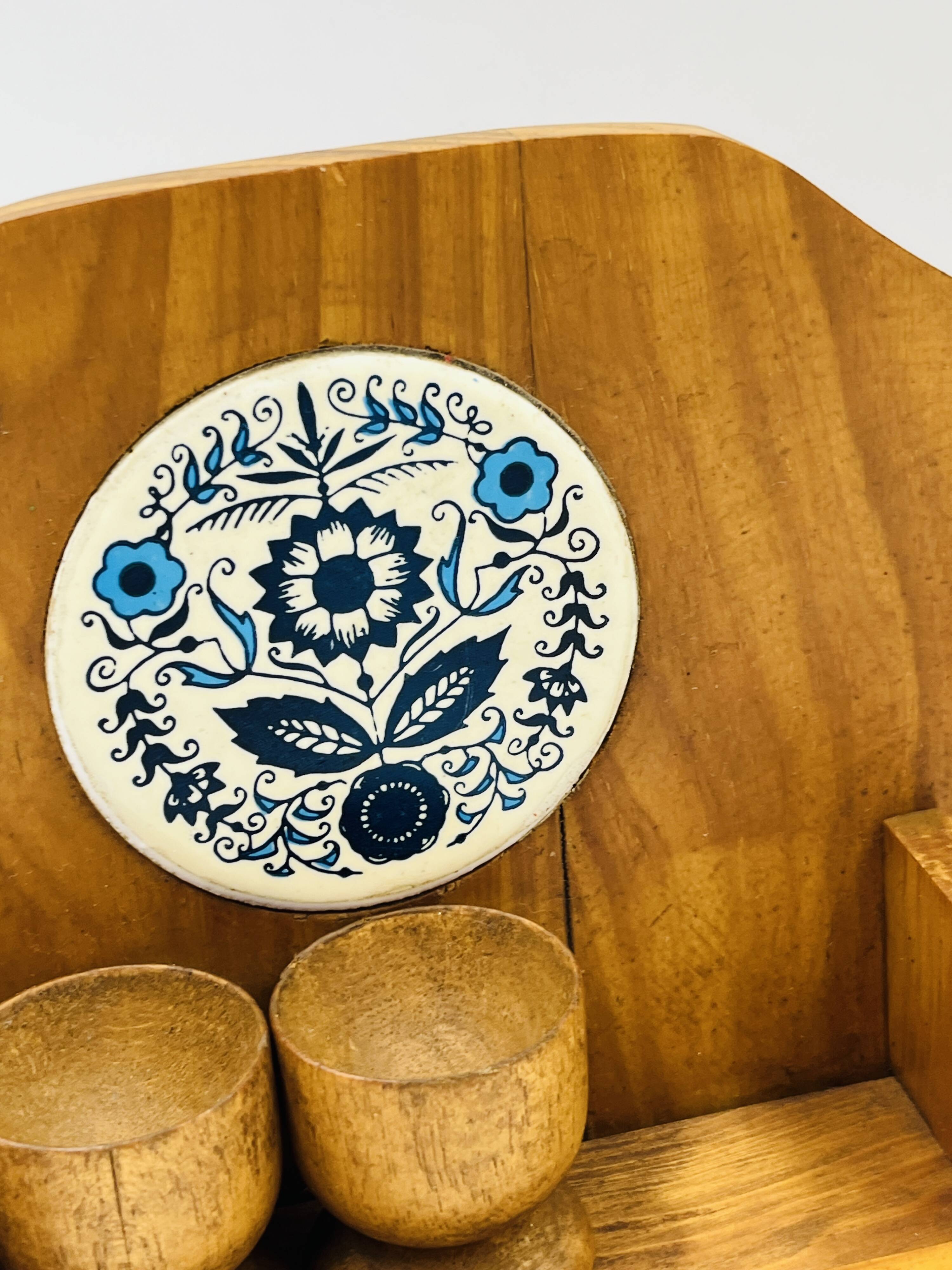 Wall-mounted egg cup holder and wooden utensil holder.