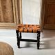 Antique turned wooden stool with woven leather.