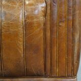 Cognac-colored cowhide 2-seater designer sofa finished with piping