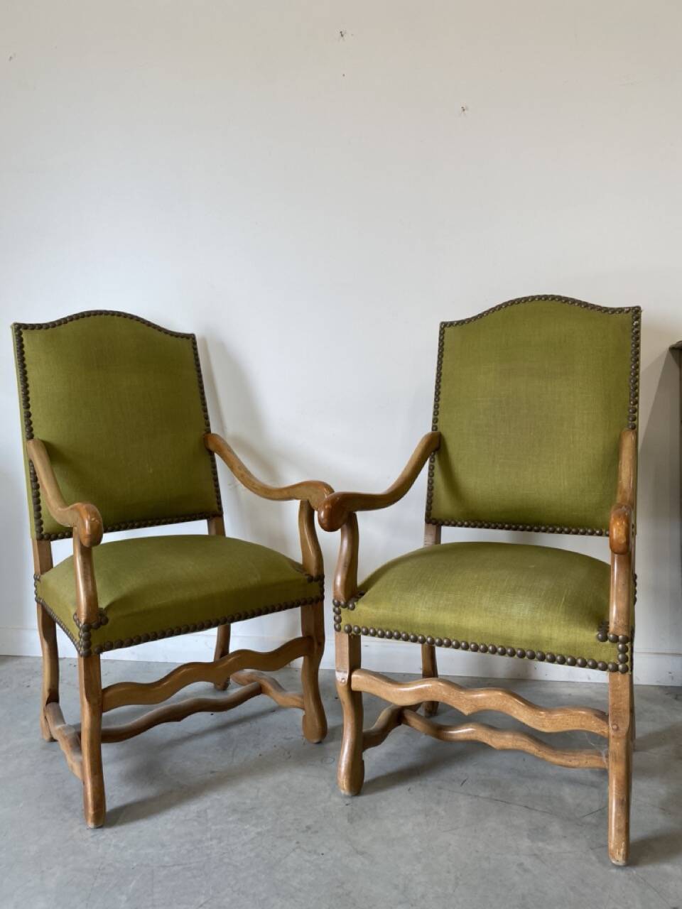 Olive green upholstered armchairs with studs