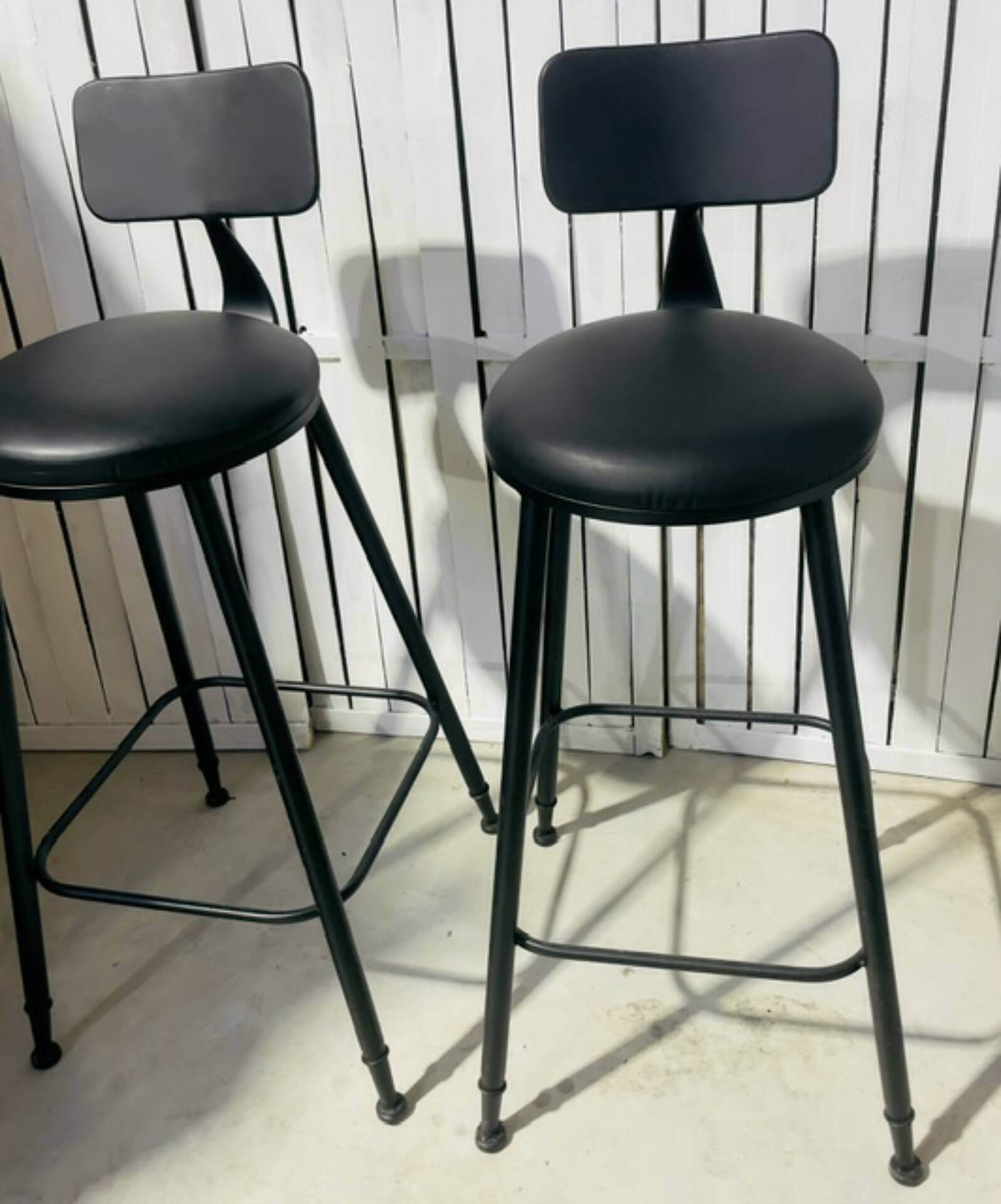 Pair of black bar stools in industrial and contemporary style.
