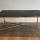 Neoclassical brass coffee table with a black leather top and golden borders from Maison Jansen.