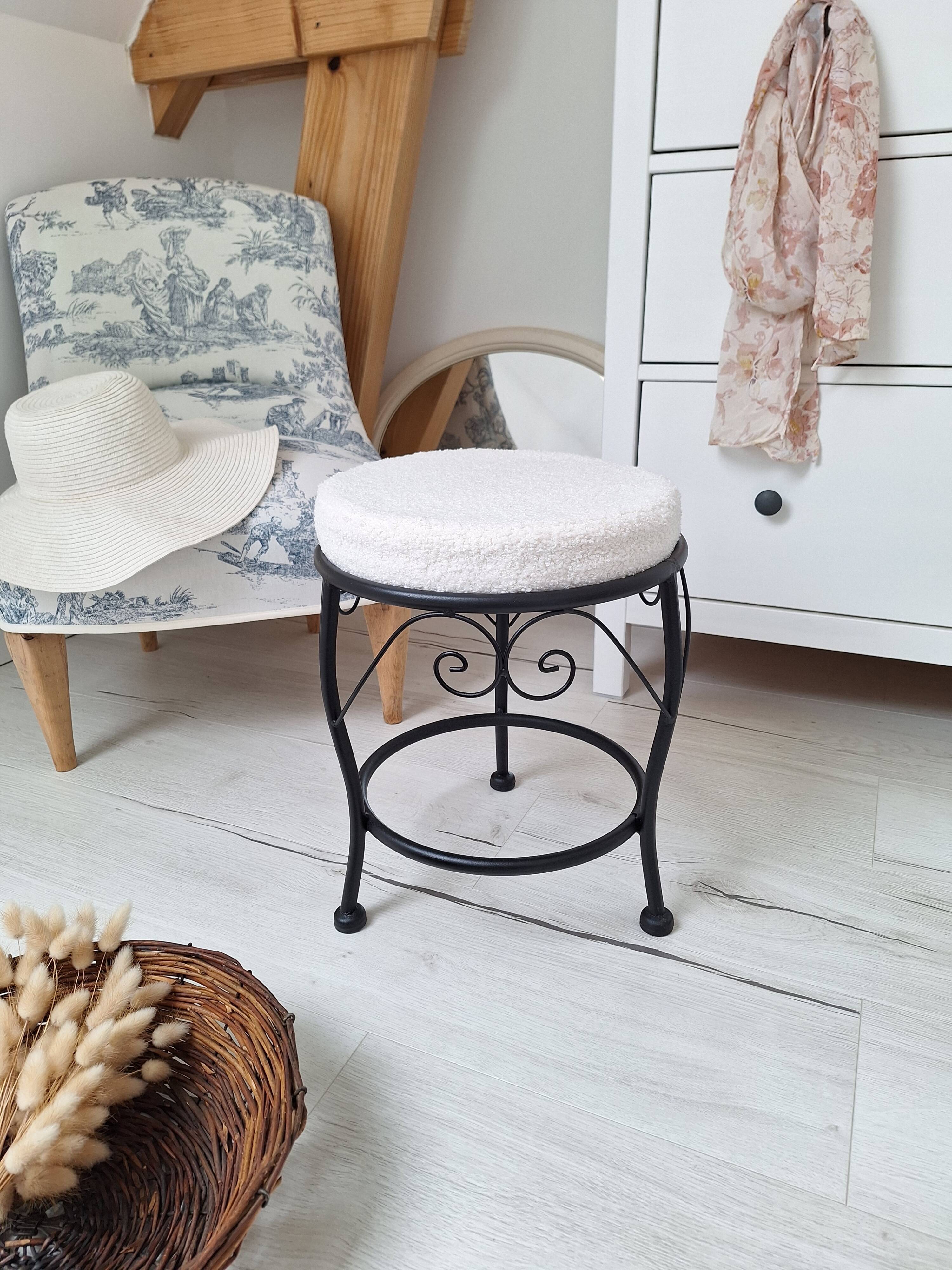 Black iron stool/pouf with its boucle fabric cushion.