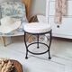 Black iron stool/pouf with its boucle fabric cushion.