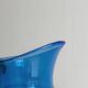 Translucent blue glass jug with a green handle.