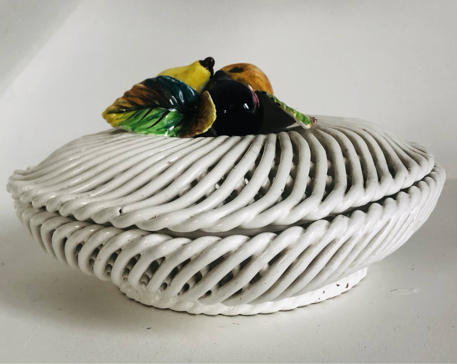 Covered basket in white woven ceramic and fruit slip.