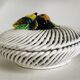 Covered basket in white woven ceramic and fruit slip.