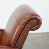 Cognac-colored sheepskin armchair with rounded shapes