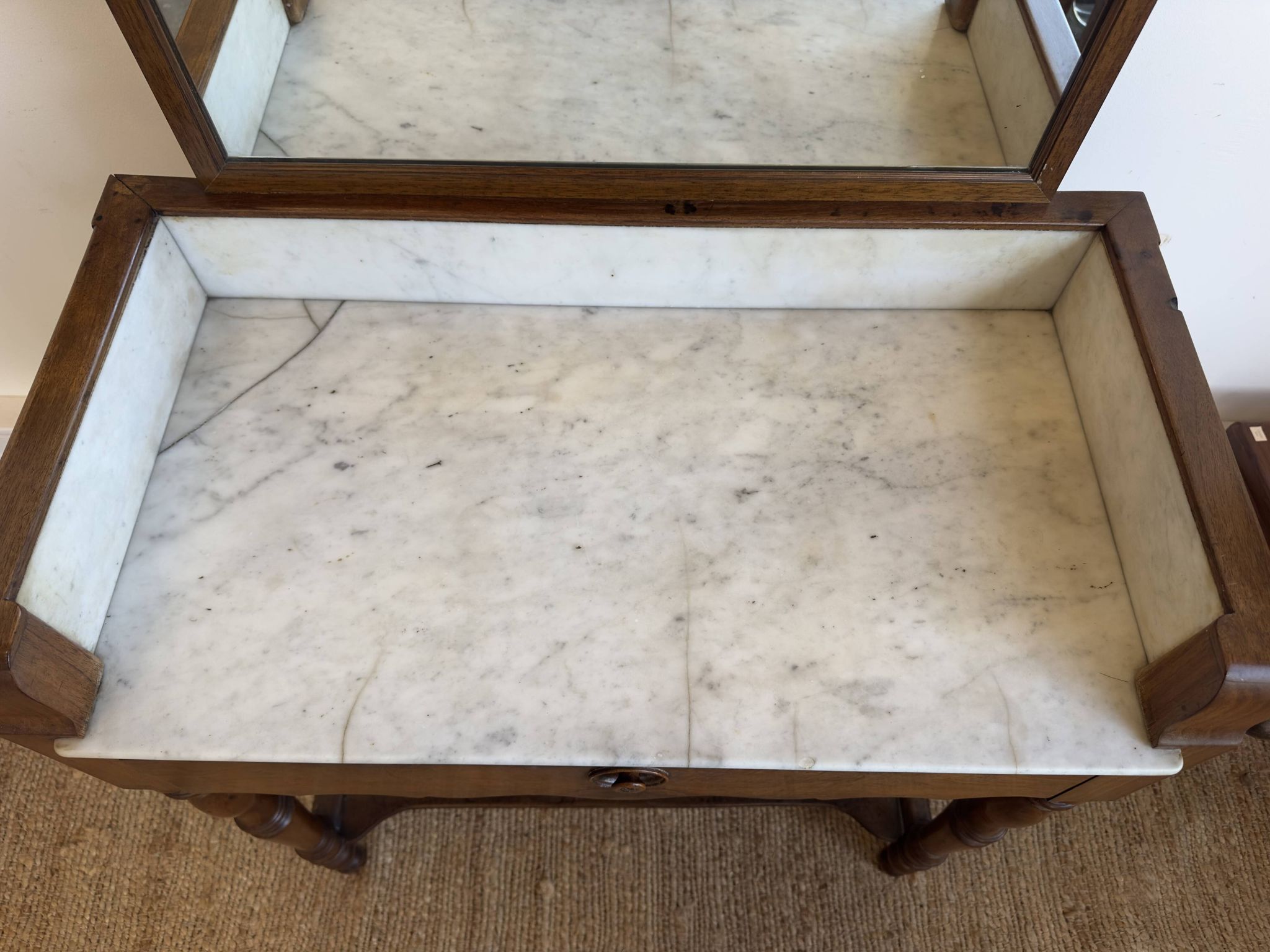 Antique bathroom cabinet with white marble and mirror.