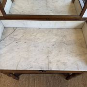 Antique bathroom cabinet with white marble and mirror.