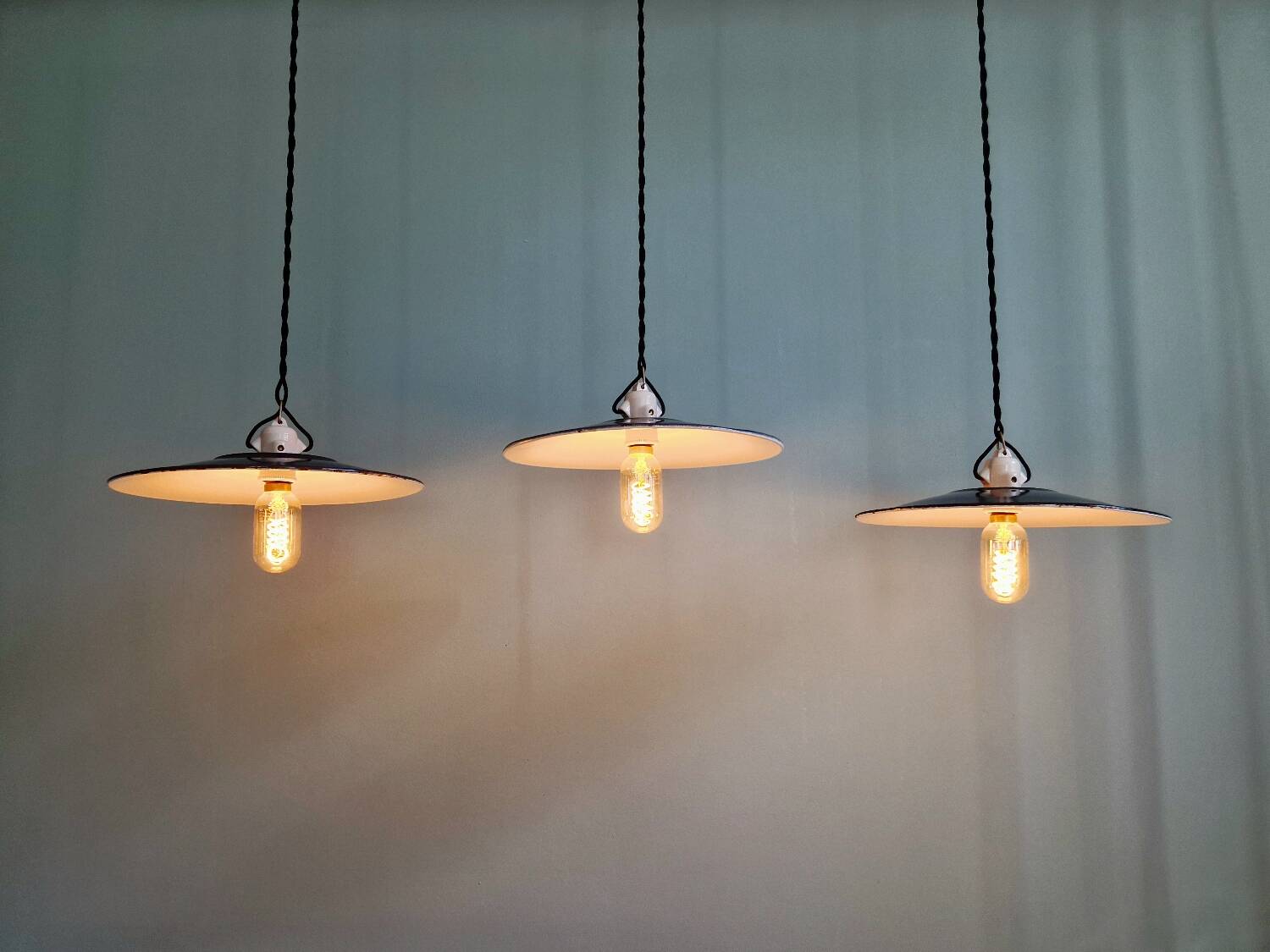 Three industrial suspensions in black enamelled sheet metal.