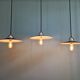 Three industrial suspensions in black enamelled sheet metal.