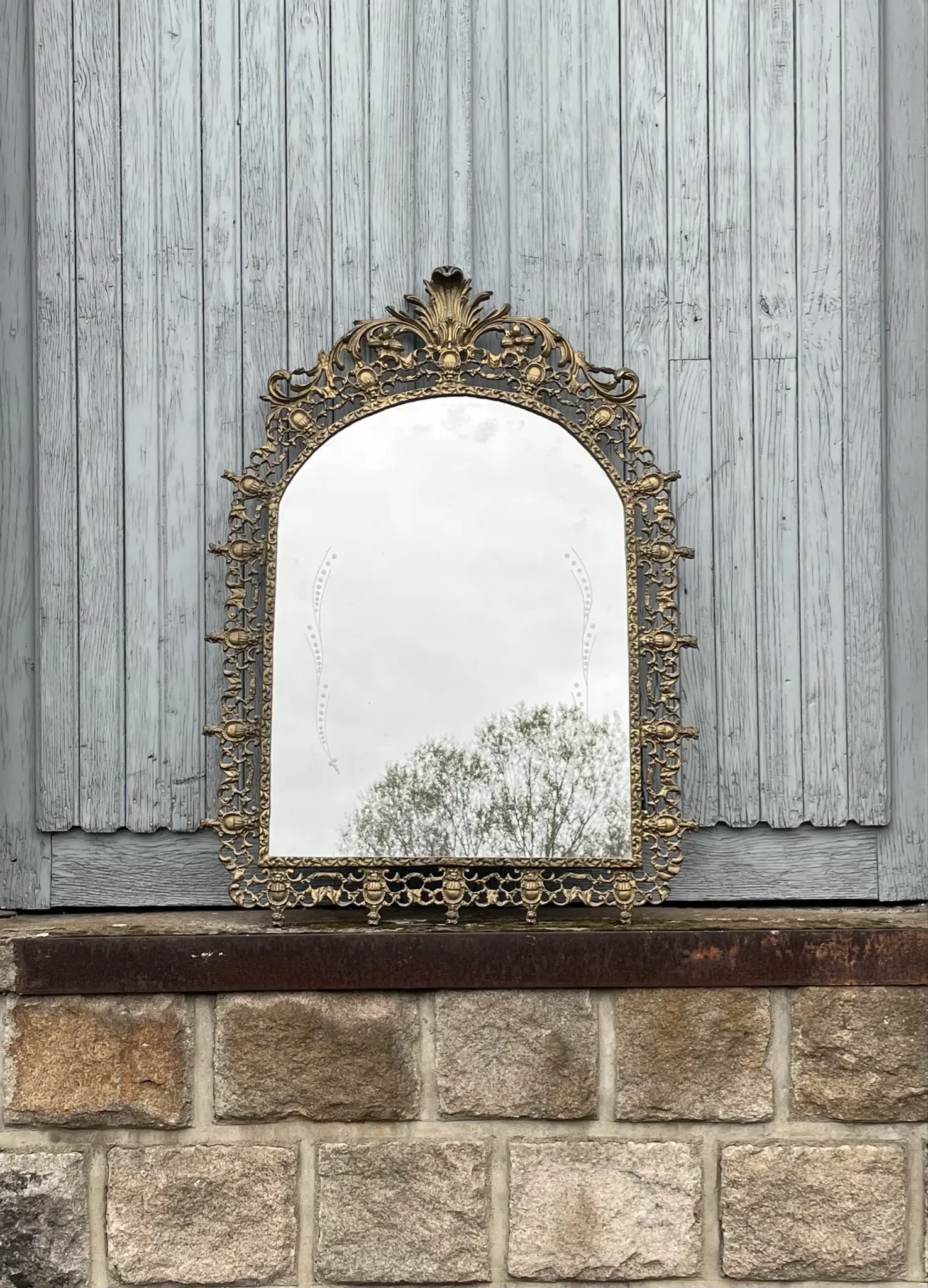 Vintage brass wall mirror adorned