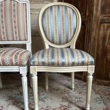 Pair of Louis XVI style chairs in painted wood and satin, classic elegance.