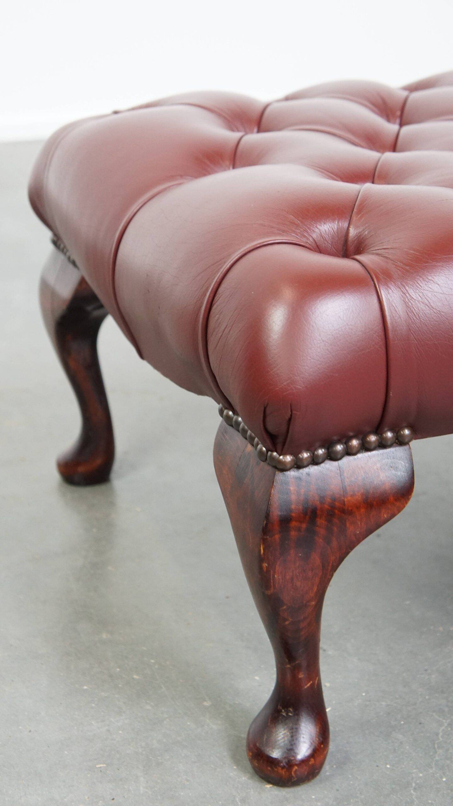 In very good condition elegant red/brown chesterfield ottoman made of cow leather