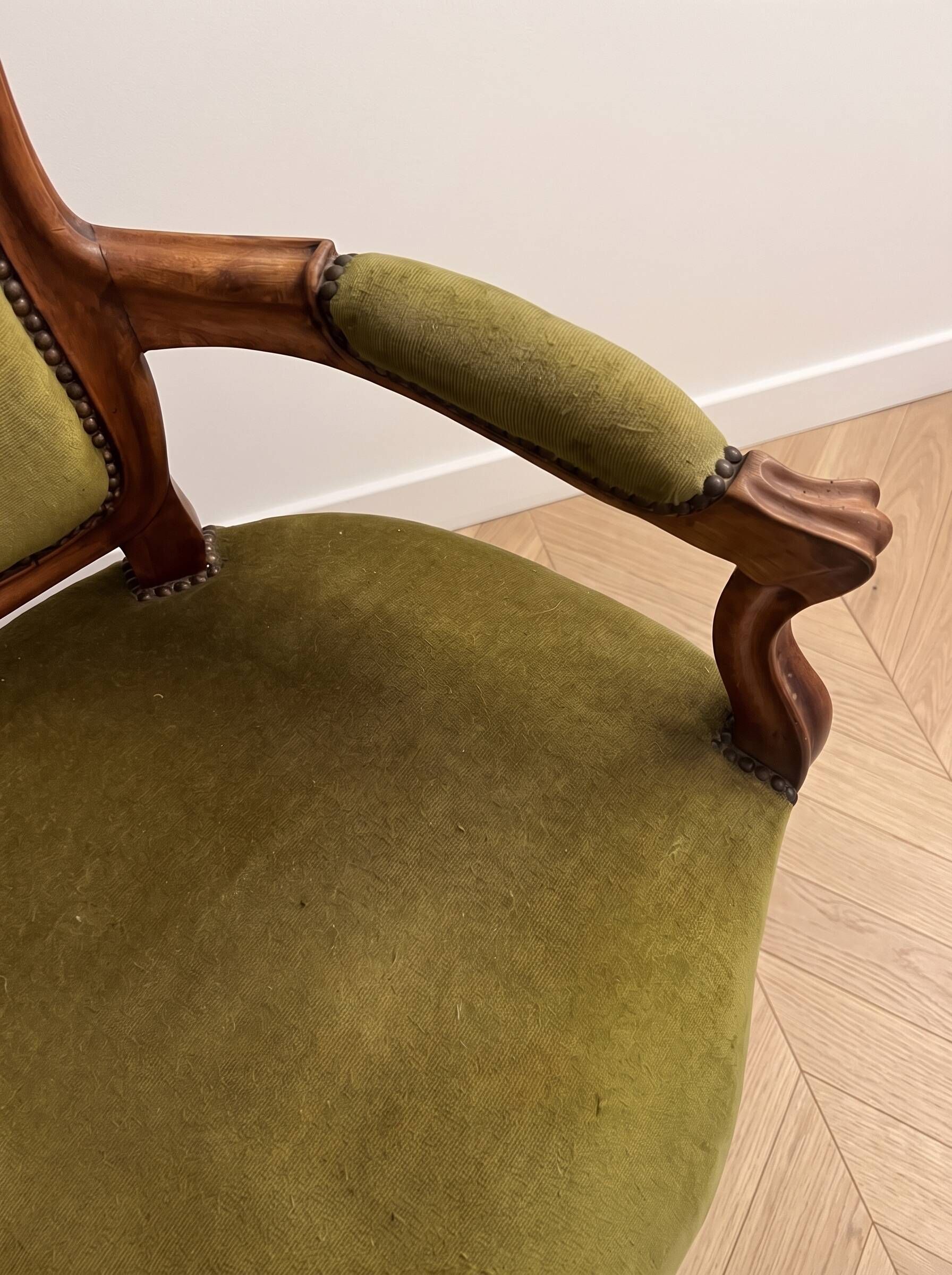 Antique armchair in olive green velvet and carved wood.