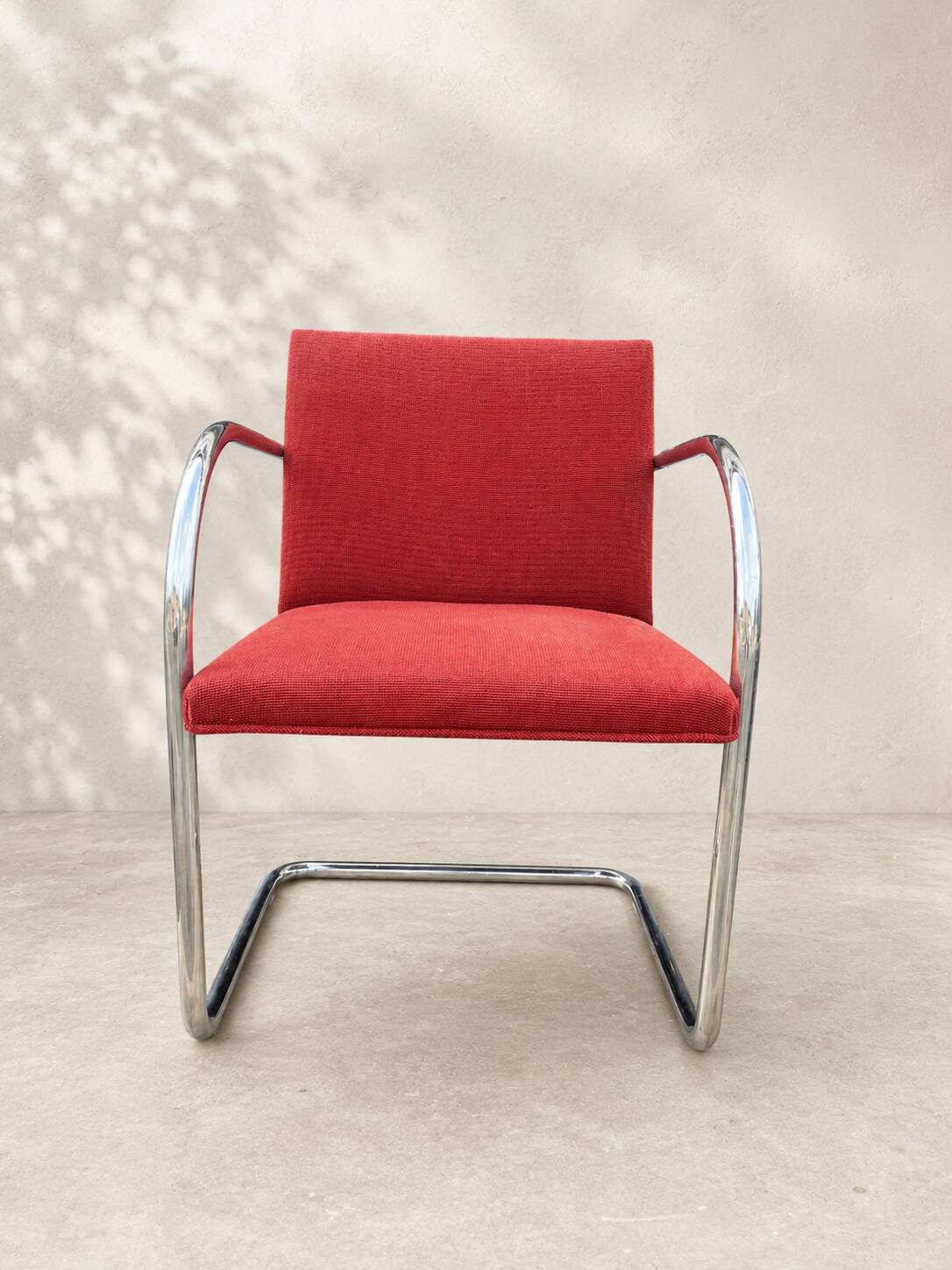 Vintage cantilever chair in chrome and burgundy fabric.