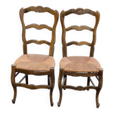 2 solid oak carved and rush-seated chairs in the Louis XV style from the 19th century.