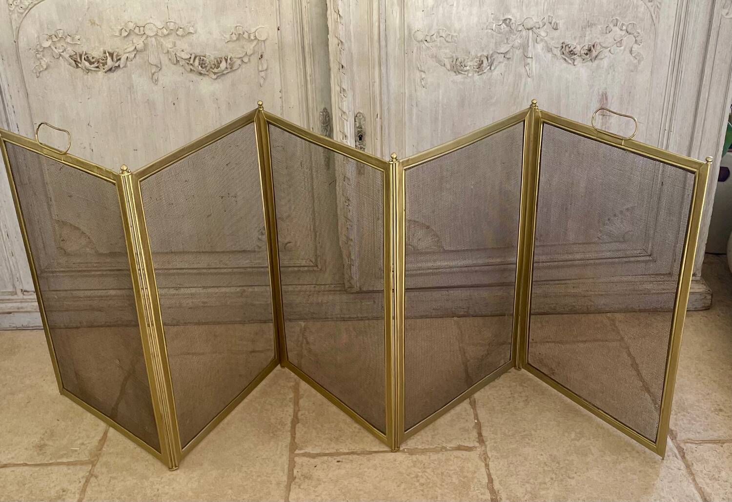 Five-panel golden metal fireplace screen from the 19th century.