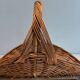 Woven Rattan Log Holder in a Semi-Round Shape with a Central Arched Handle.