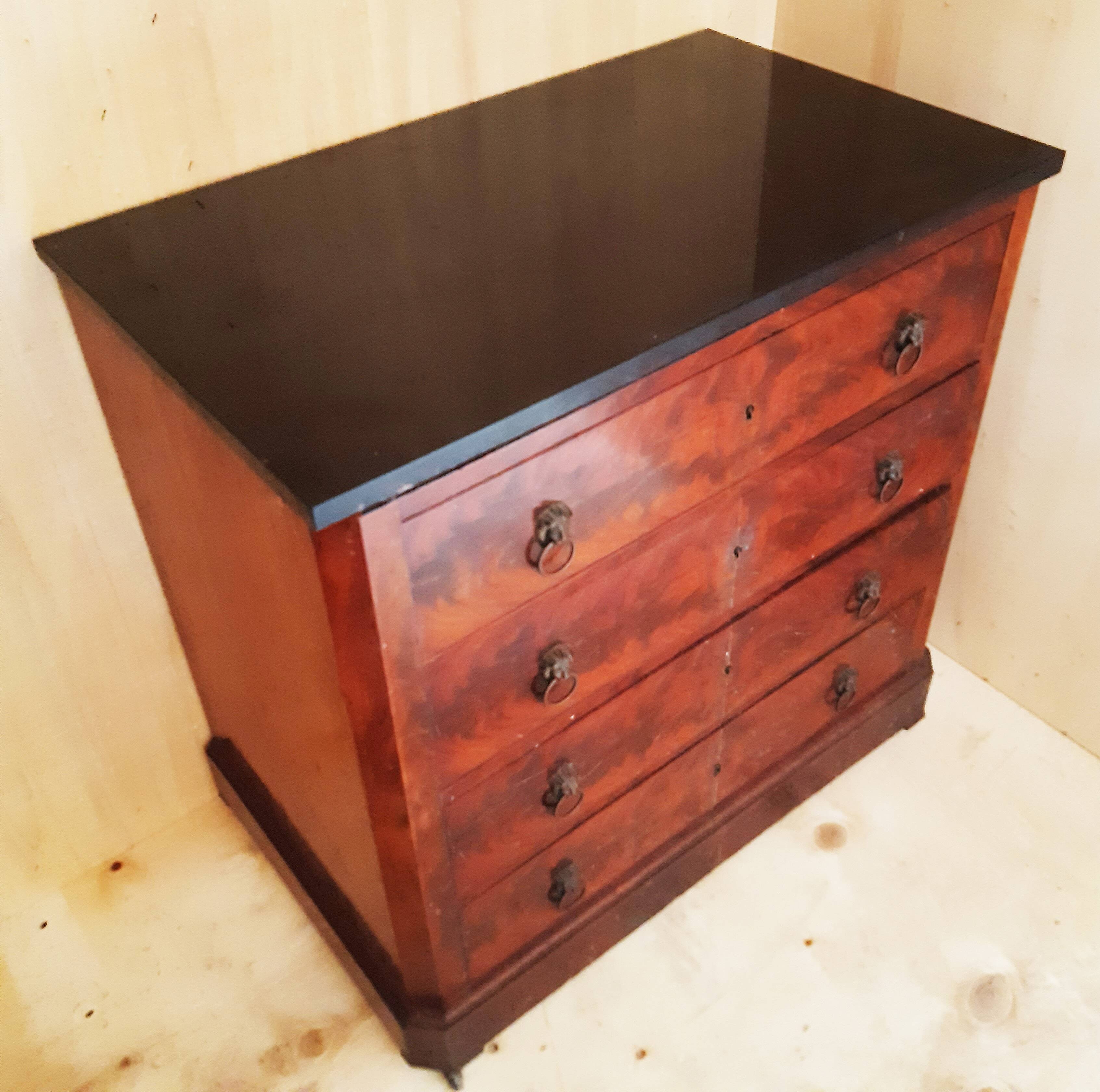Antique chest of drawers with mahogany veneer and lion heads