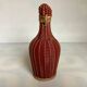 Small decorative bottle in burgundy wicker.