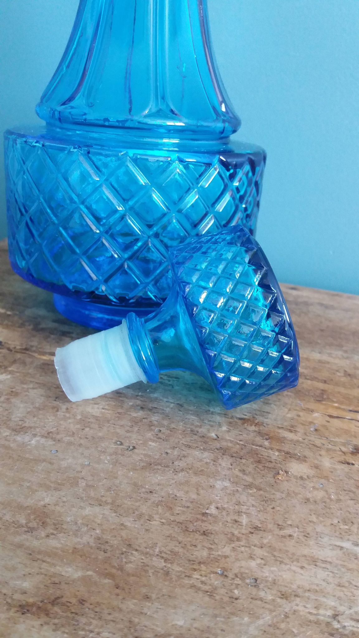 Turquoise glass carafe bottle with a stopper.
