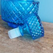 Turquoise glass carafe bottle with a stopper.