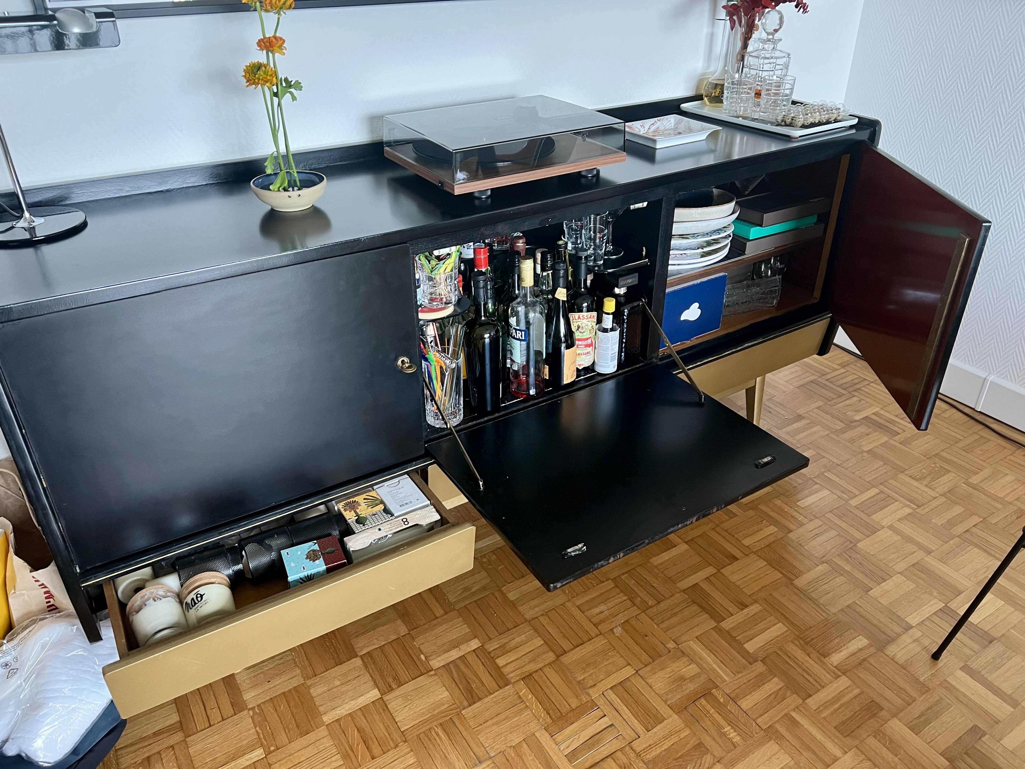 Black buffet cabinet including a bar and 3 drawers.