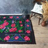 Handwoven floral wool rug, black background with pink roses