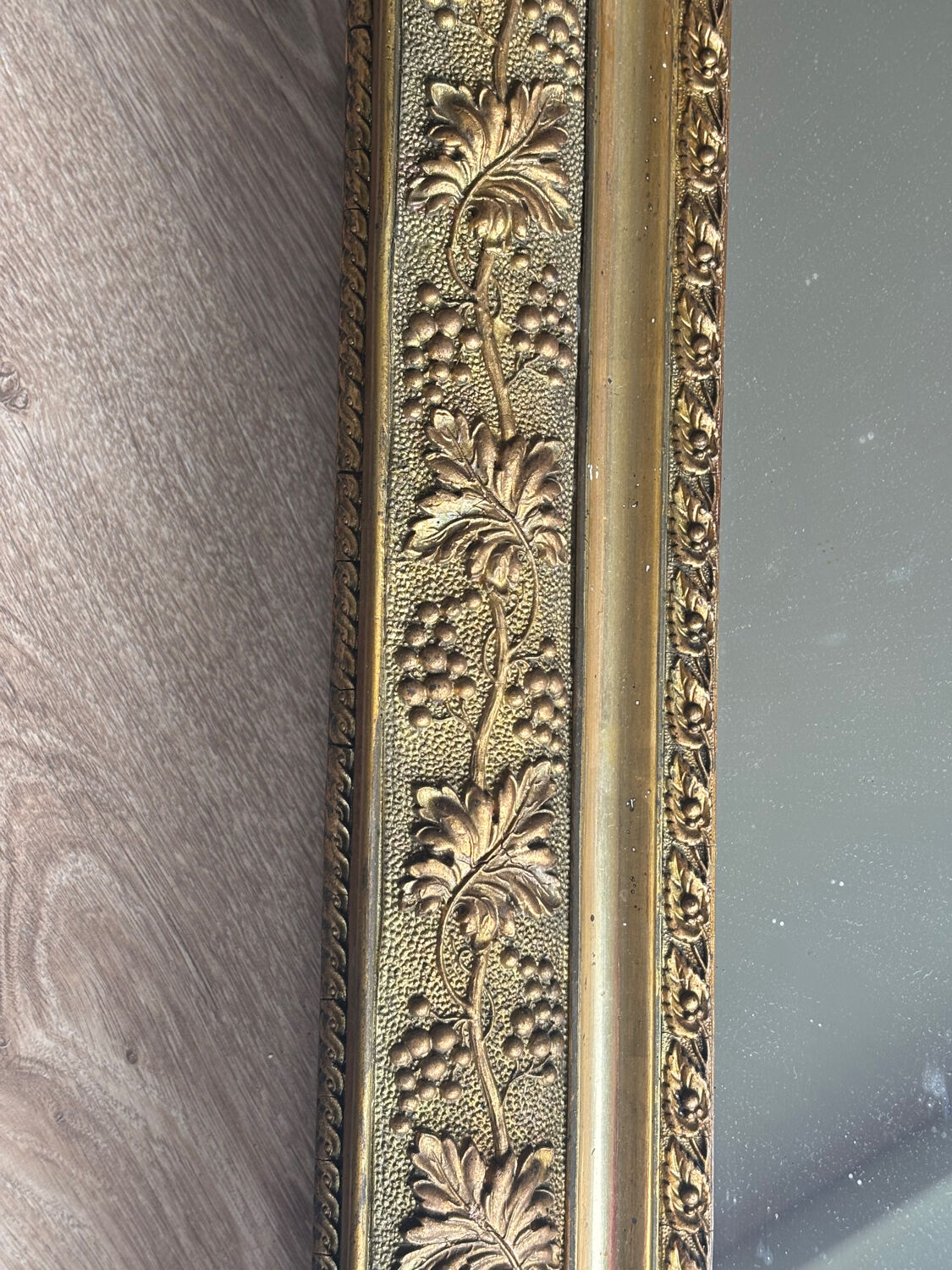 Golden mirror with a pediment from the early 20th century.