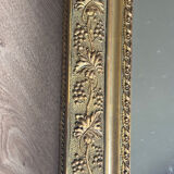 Golden mirror with a pediment from the early 20th century.