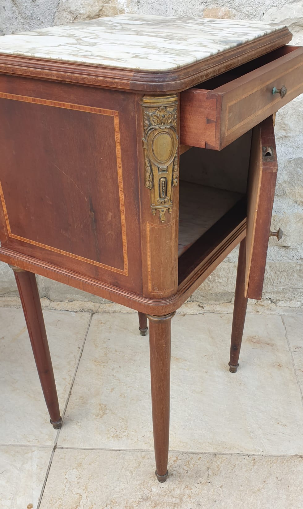 Old wooden bedside table on marble top