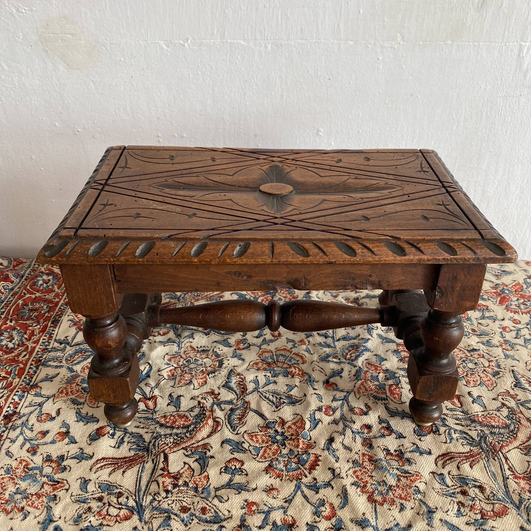 Low stool in carved wood