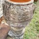 Large Cretan jar in terracotta with three handles on a stone base.