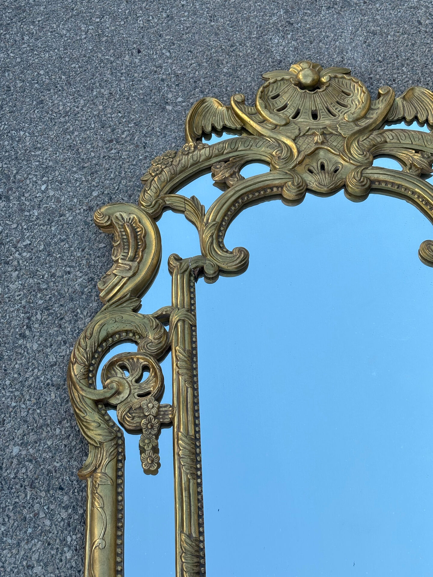 Large mirror with carved and gilded wooden frame, in Regency style.