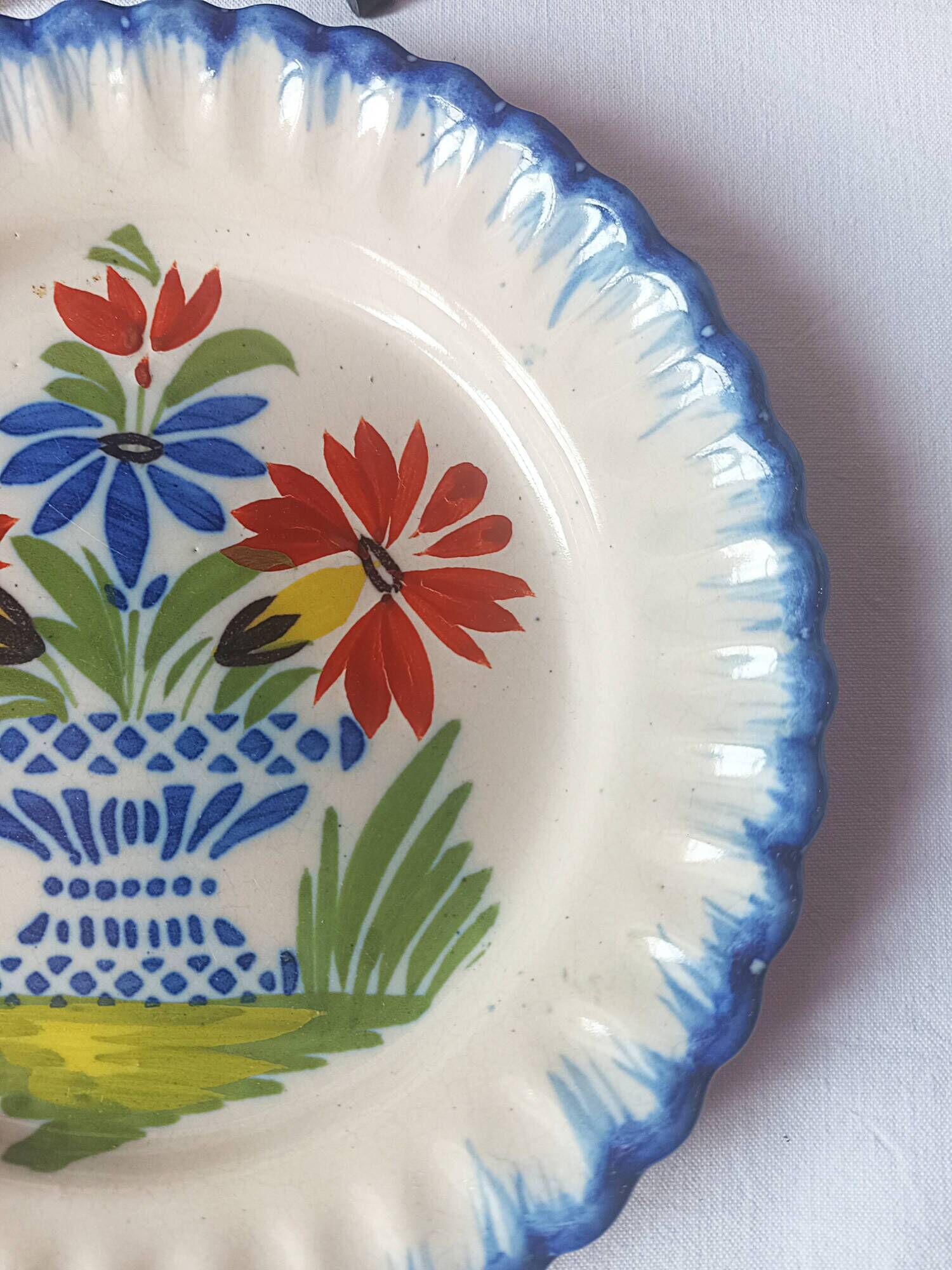 Pair of antique plates in popular earthenware with a floral basket decoration on the edge.