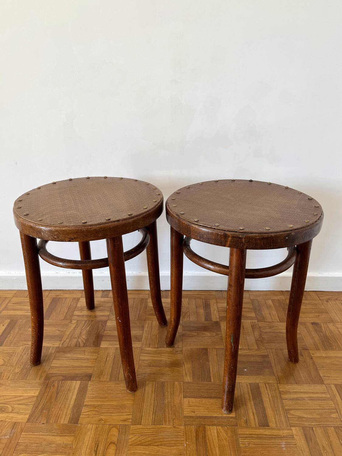 2 antique bistro stools with curved wood and caning effect.