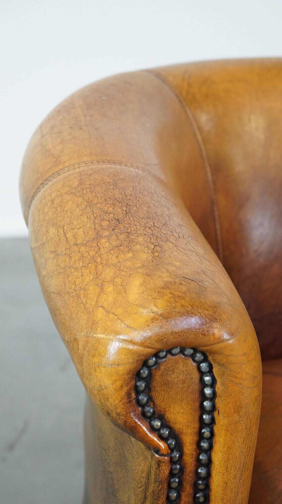 Fauteuil club en peau de mouton subtile avec finition cloutée décorative