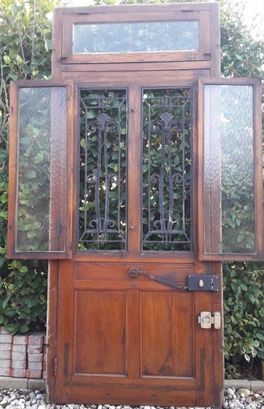 Oak entrance door and its frame and transom, wrought iron gates