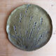 Decorative wall plaque in brass with a floral design.